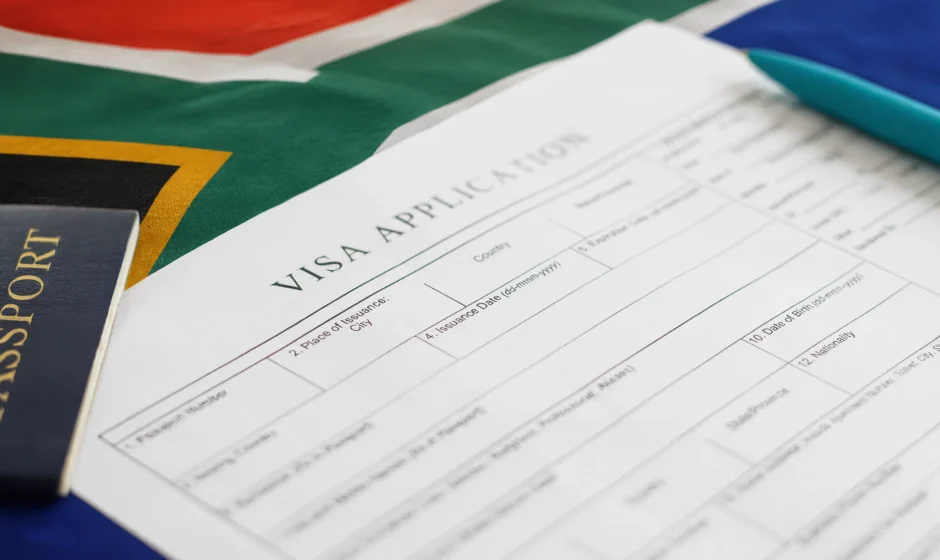 Passport and visa application form on top of a South African flag representing South Africa work visa requirements