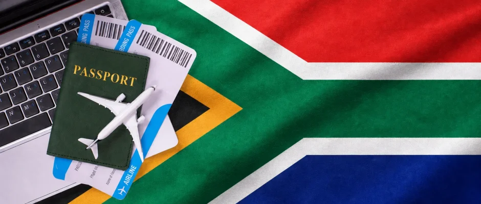 South Africa Remote Work Visa 2026 with laptop and passport on South African flag South Africa Remote Work Visa 2026 with laptop and passport on South African flag