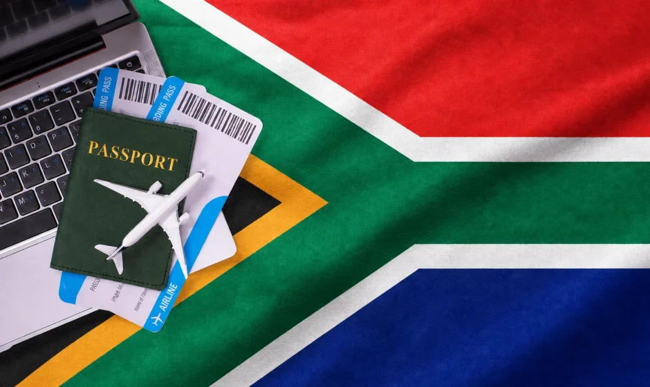 South Africa Remote Work Visa 2026 with laptop and passport on South African flag South Africa Remote Work Visa 2026 with laptop and passport on South African flag