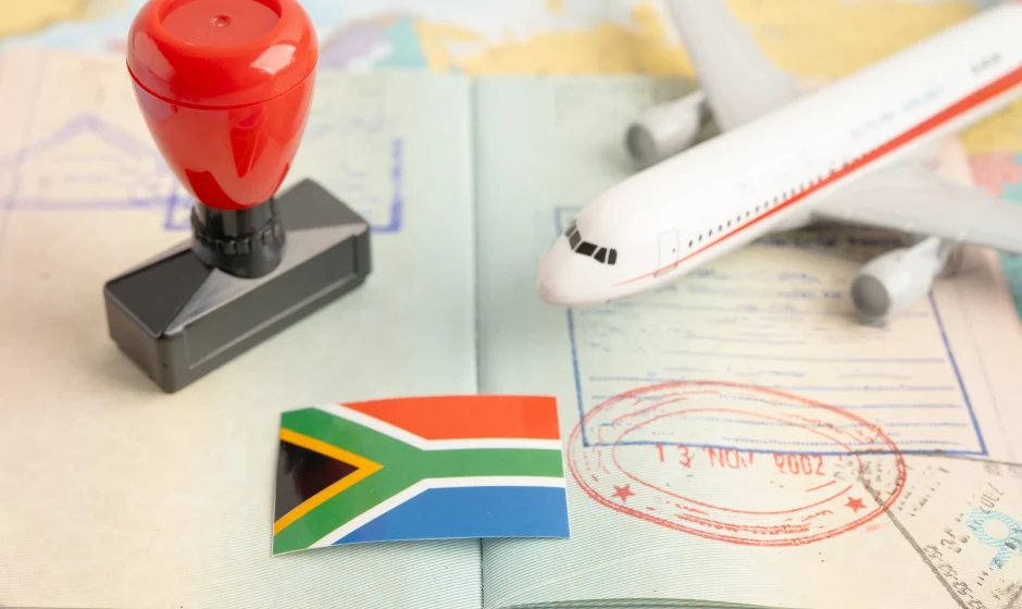 How to get a South African tourist visa with passport, South African flag, visa stamp and airplane